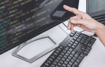 a person pointing at the data displayed on a computer screen