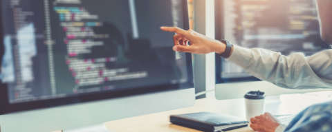a person pointing at the data displayed on a computer screen