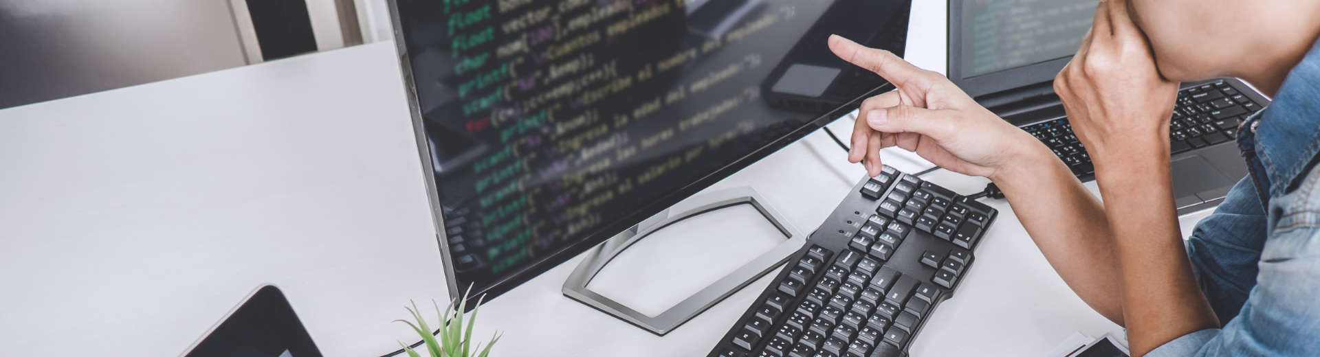 a person pointing at data displayed on a computer screen