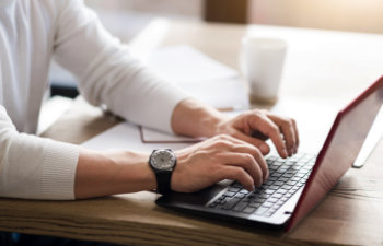 man typing on the laptop keyboard in the office