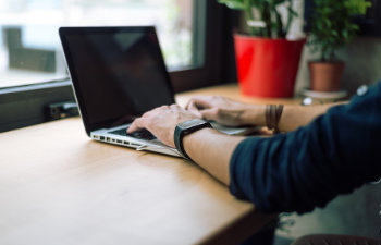 young bearded manager working and reading data on laptop in home office