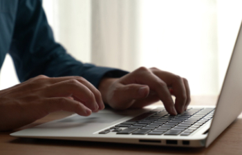 young bearded manager working and reading data on laptop in home office